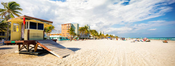 Hollywood beach Florida panoramic landscape on a sunny Winter day with lifeguard hut to the left. crowd of people enjoying the beach in the background.