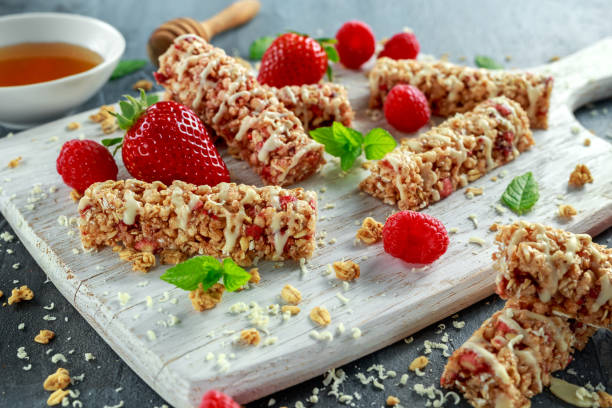 istock Granola bar with strawberries, raspberry honey and white chocolate on cutting board 669720420