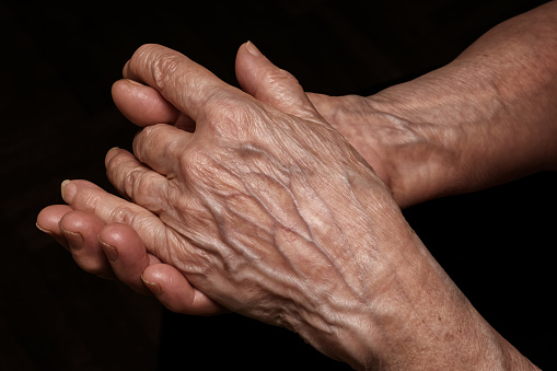 Mujer senior doblada arrugadas manos cerca. Edad avanzada, problemas de edad, tema de la pobreza y la soledad photo