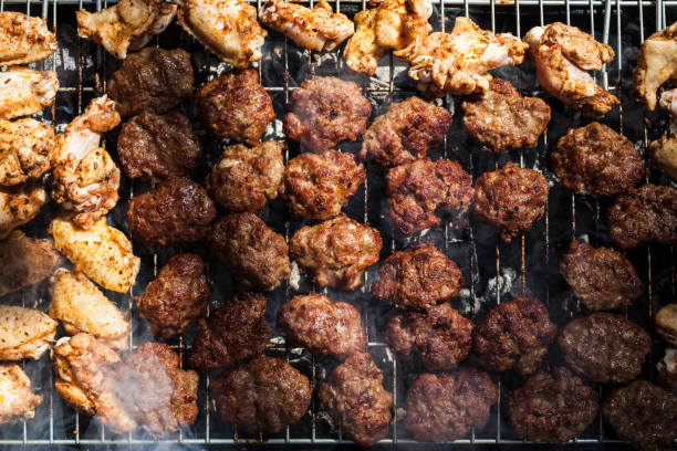 Large amount of meatballs and chicken nuggets on grill in outdoor for barbecue party.No people are seen in frame.Shot in outdoor with a full frame DSLR camera.Horizontal framing.
