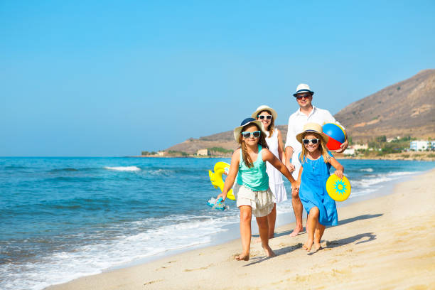 glückliche junge familie, die spaß am strand bei sonnenuntergang. familienreisel-konzept - strandurlaub stock-fotos und bilder