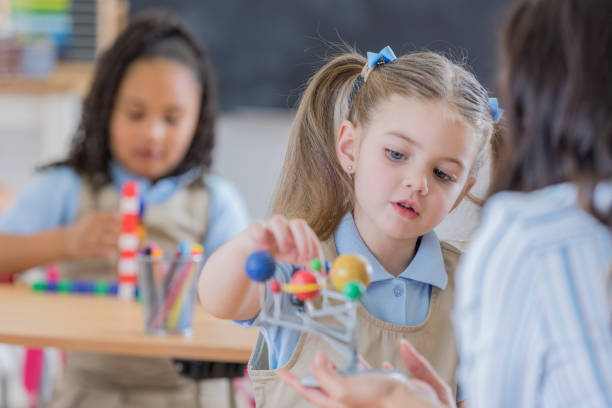 istock Little girl concentrates while learning about the solar system 669745216