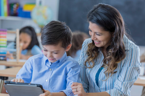 istock Confident young schoolboy uses technology at school 669745248