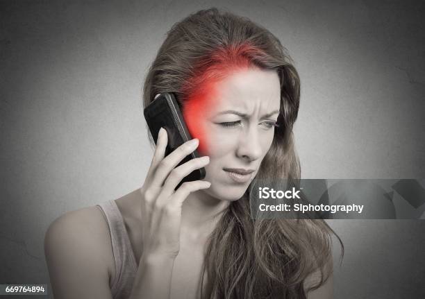 Girl On The Phone With Headache Upset Unhappy Female Talking On Phone Stock Photo - Download Image Now