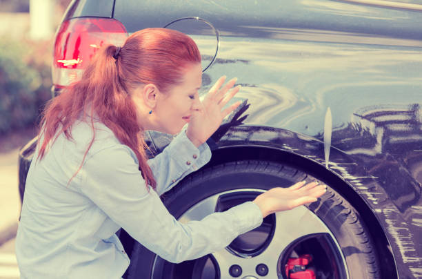 разочарованная молодая женщина проверяет указывая на автомобильные царапины и вмятины на открытом воздухе снаружи - ding стоковые фото и изображения