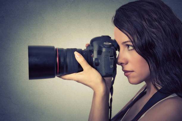 istock Side profile young woman taking pictures with professional camera 669768266