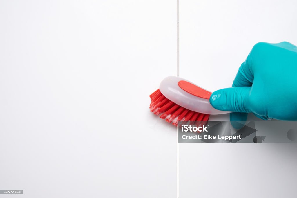 Männliche Hand mit roten Pinsel reinigen der Fliesen im Bad und Lücken. Vor und nach der Wirkung. - Lizenzfrei Reinigen Stock-Foto