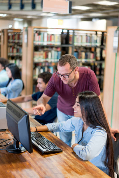 lehrer helfen studenten in der bibliothek - professor librarian university library stock-fotos und bilder