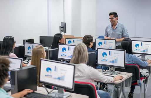 Group of high school students studying over laptops on a class at school.