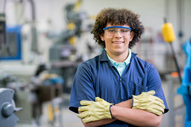 Portrait of an engineering student in a workshop Portrait of a male engineering student in a workshop looking at the camera smiling - education concepts industrial designer stock pictures, royalty-free photos & images