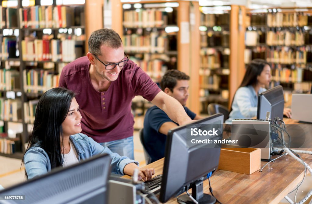 Librarian Using Computer Librarian Helping Students Using Computers At The Library Stock Photo ...
