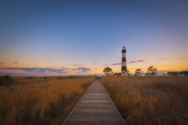 Boardwalk Leading to Bodie Island Lighthouse A boardwalk through the marsh at Bodie Island Light, North Carolina. bodie island stock pictures, royalty-free photos & images
