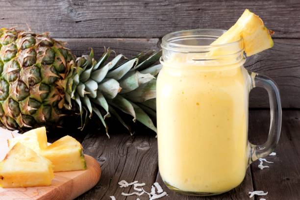 ananas-smoothie in ein einmachglas, szene gegen holz - mason stock-fotos und bilder