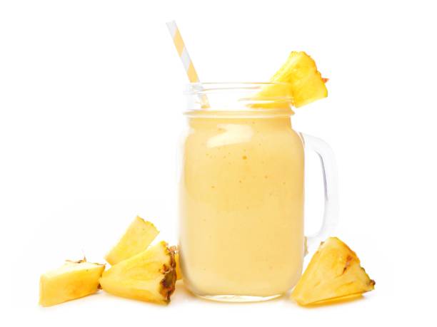 istock Pineapple smoothie in a mason jar with fruit slices over white 669779444