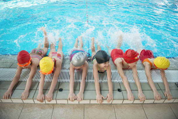 istock happy children kids group at swimming pool class learning to swim 669780224