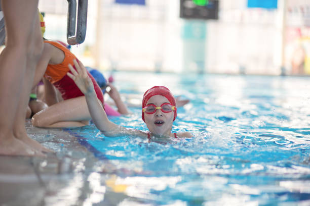istock happy children kids group at swimming pool class learning to swim 669782566