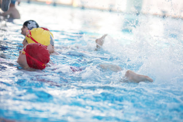istock happy children kids group at swimming pool class learning to swim 669784870