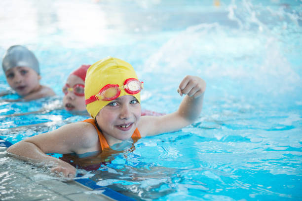 istock happy children kids group at swimming pool class learning to swim 669784982