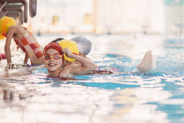 istock happy children kids group at swimming pool class learning to swim 669785036