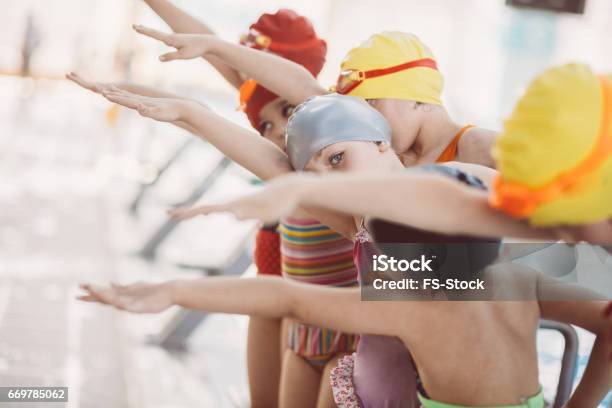 Instructor And Group Of Children Doing Exercises Near A Swimming Pool Stock Photo - Download Image Now