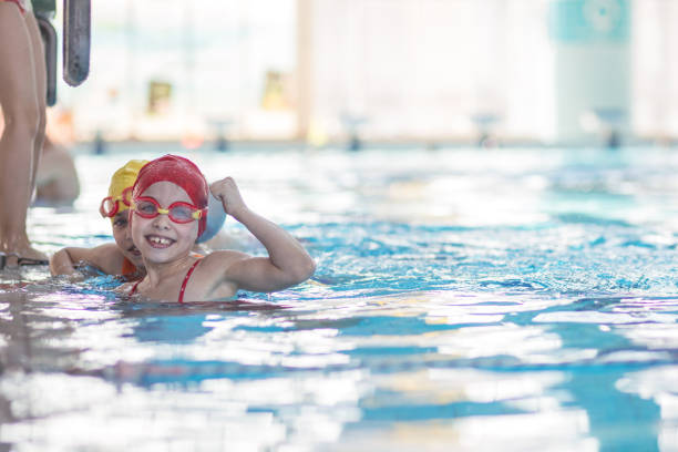 istock happy children kids group at swimming pool class learning to swim 669785652