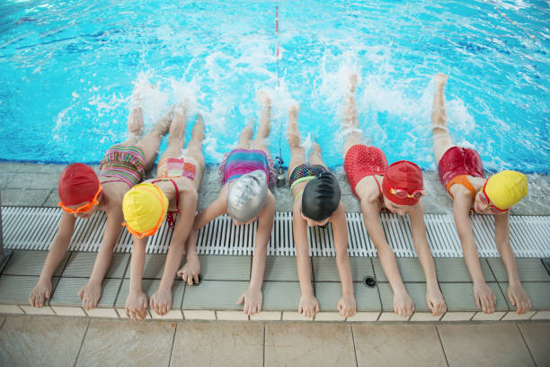 happy children kids group at swimming pool class learning to swim - damp course imagens e fotografias de stock