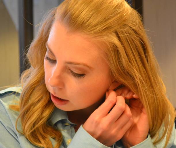 istock Young Woman Putting on an Earring 669807368
