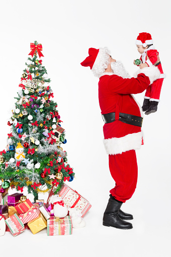 santa father holding his daughter by christmas tree on white background.
