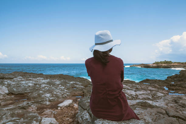 istock Young woman sitting at cliff 669839376