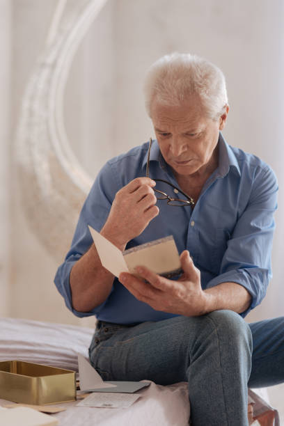 istock Unhappy gloomy man holding an old postcard 669842464
