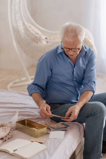 istock Pleasant senior man turning over old letters 669842520