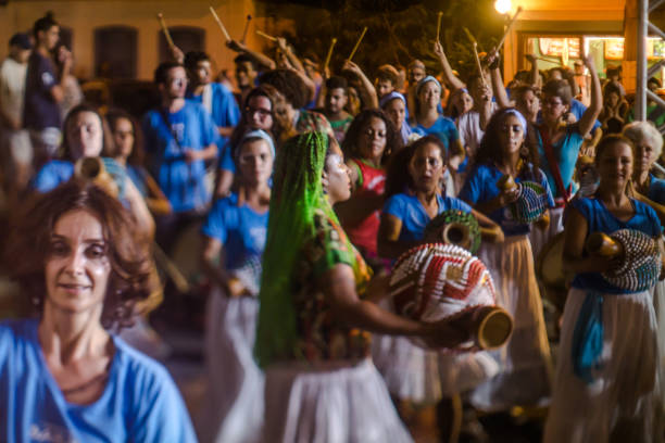 cortejo de maracatu - dança folclórica tradicional com raízes africanas - com o grupo batuki kianda em ilhabela, brasil, em 16 de abril de 2017, andando pelas ruas do centro histórico da cidade. fotos feitas com uma lente tilt-shift. - lens barrel - fotografias e filmes do acervo