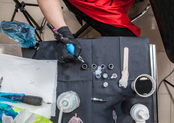 istock Tattoo artist table while she is refilling the gun 669853688