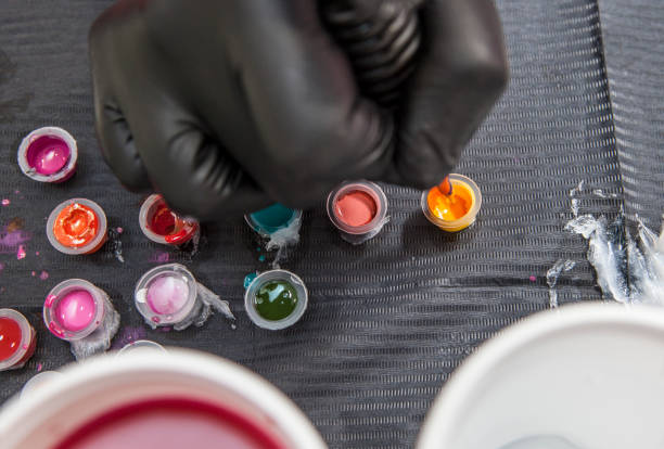 istock Tattoo artist refilling the pen with yellow ink 669853720