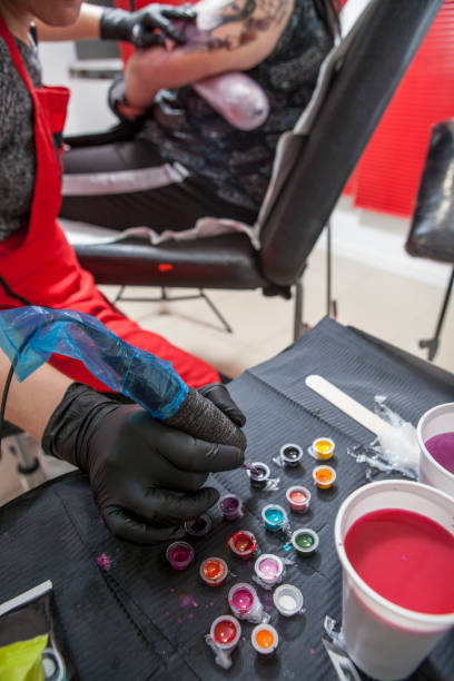 istock Woman tattoo artist refilling her pen 669853732