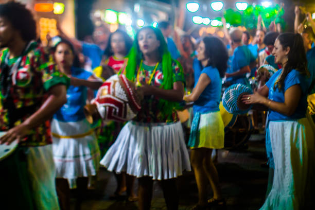 cortejo de maracatu - dança folclórica tradicional com raízes africanas - com o grupo batuki kianda em ilhabela, brasil, em 16 de abril de 2017, andando pelas ruas do centro histórico da cidade. fotos feitas com uma lente tilt-shift. - lens barrel - fotografias e filmes do acervo