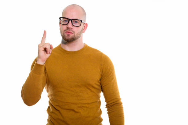 istock Studio shot of young bald muscular man pointing finger up 669858812