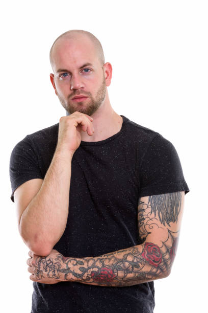istock Studio shot of young bald muscular man with tattoos thinking 669859292
