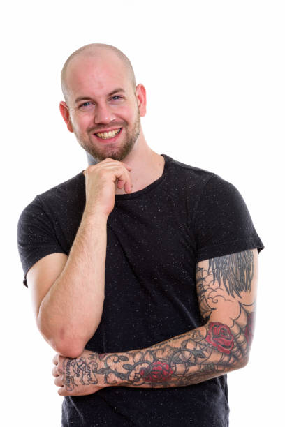 istock Studio shot of young happy bald muscular man with tattoos smiling while thinking 669860992