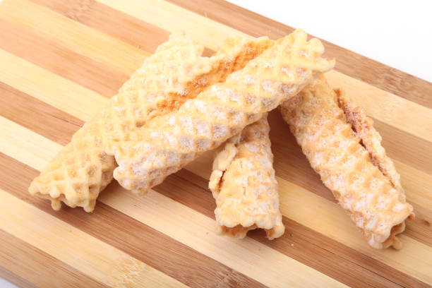istock Homemade wafer rolls with powdered sugar isolated on white background 669862480