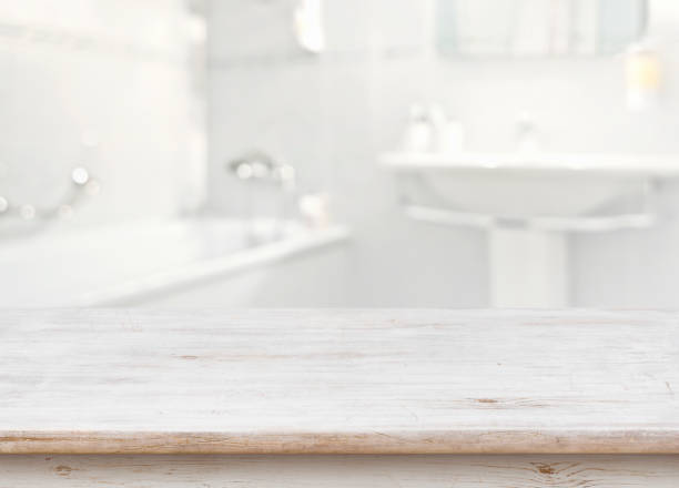 istock Wooden table in front of blurred bathroom interior as background 669872674
