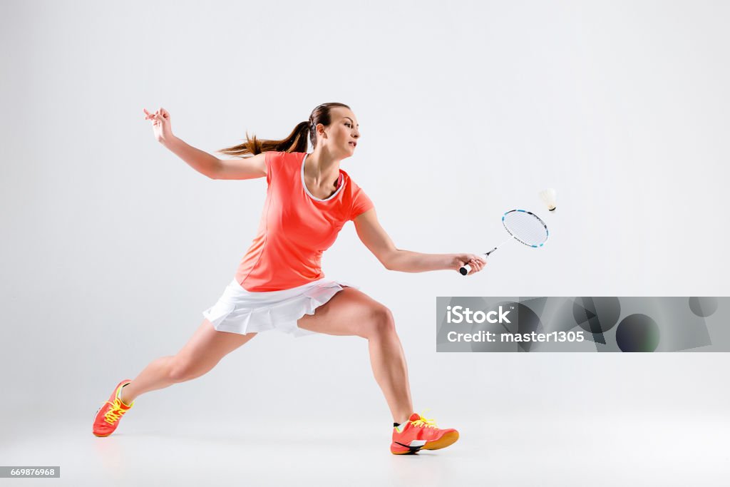 Young woman playing badminton over white background Young woman playing badminton over white studio background Badminton - Sport Stock Photo