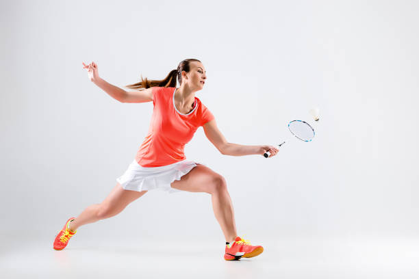 Young woman playing badminton over white background Young woman playing badminton over white studio background badminton stock pictures, royalty-free photos & images
