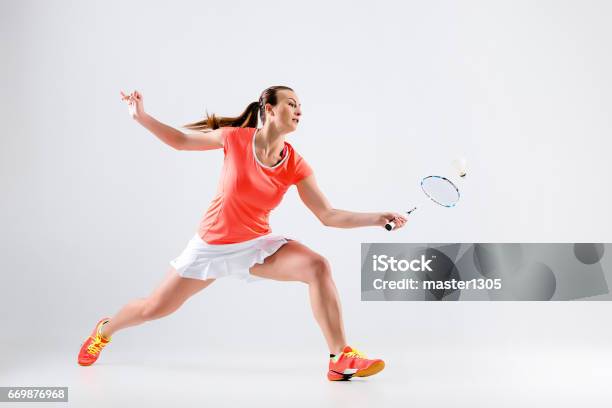 Young Woman Playing Badminton Over White Background Stock Photo - Download Image Now