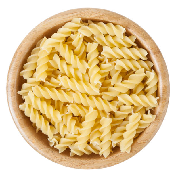 istock Fusilli pasta in wooden bowl isolated on white background with clipping path 669878290