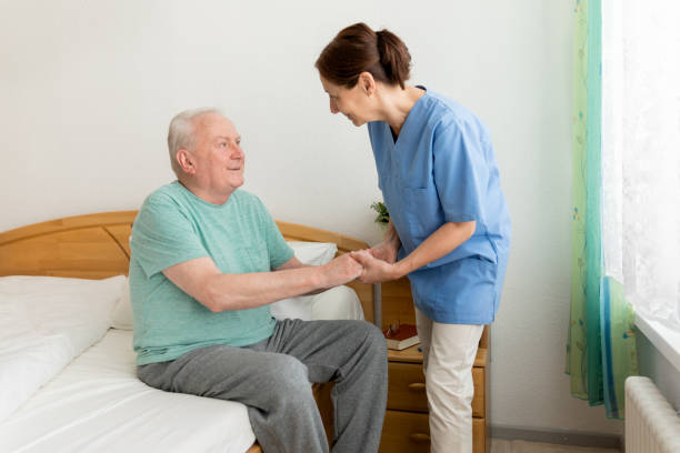 istock Female caregiver helping senior man 669884966