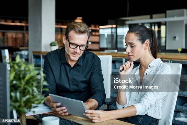 Colleagues Using Tablet Pc In Textile Factory Stock Photo - Download Image Now - Business, Office, Discussion