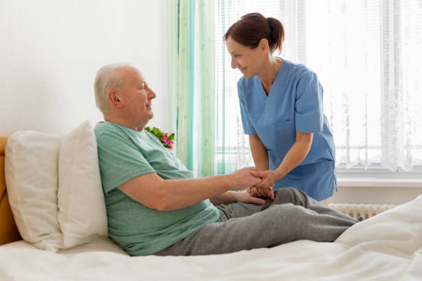 istock Female caregiver helping senior man 669887546