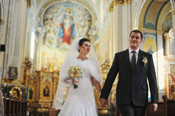 Close up groom putting wedding ring to bride's finger in the wedding ceremony
