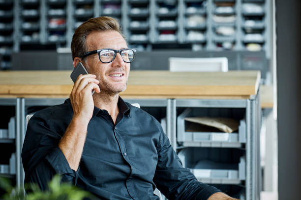 geschäftsmann mit handy in textilfabrik - smart phone business person computer businessman stock-fotos und bilder